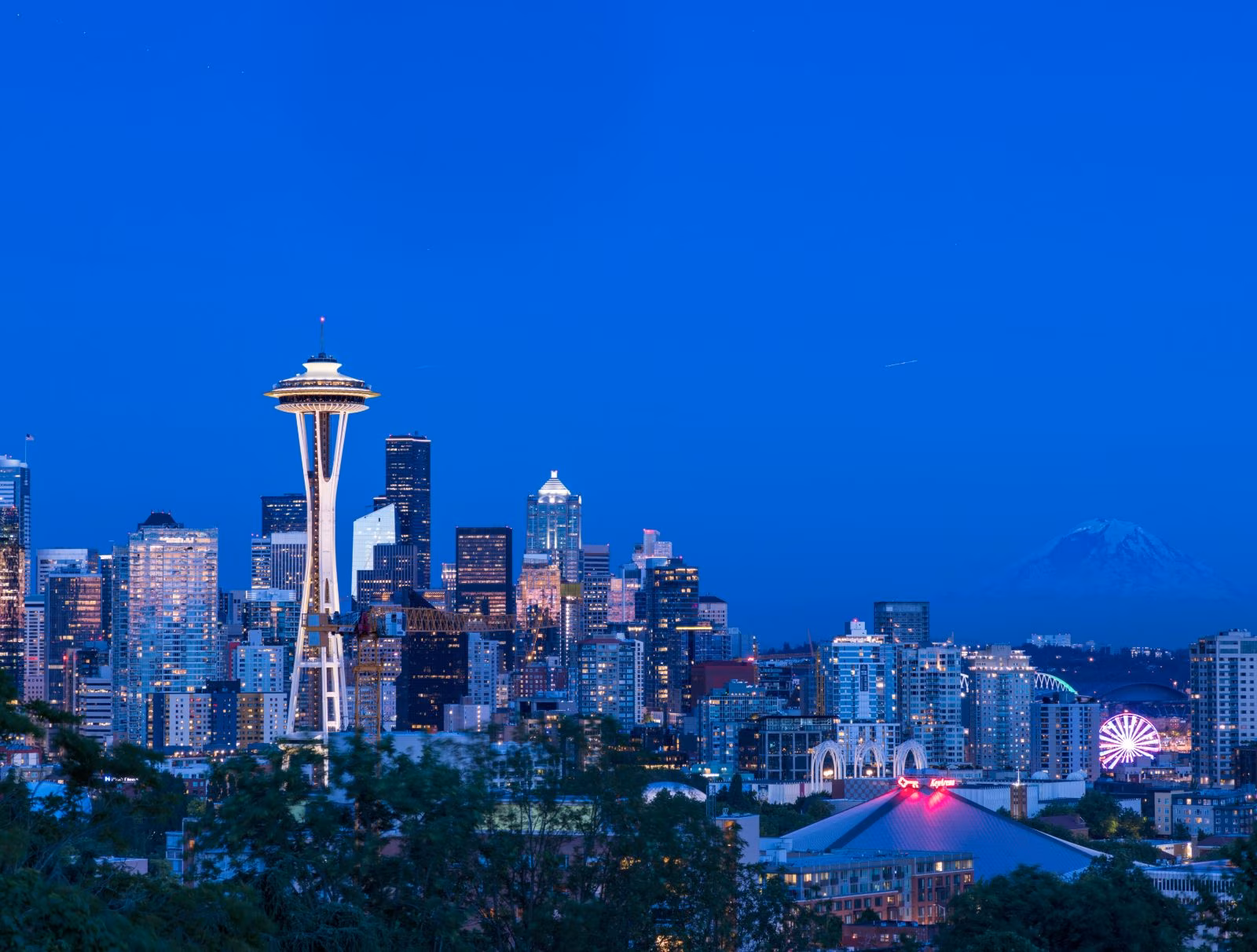 The Seattle skyline at dusk, with the Space Needle and Mount Rainier in the distance
